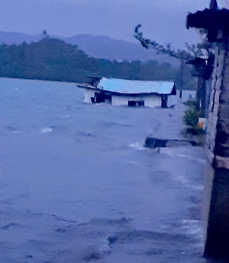 Waves submerge a house