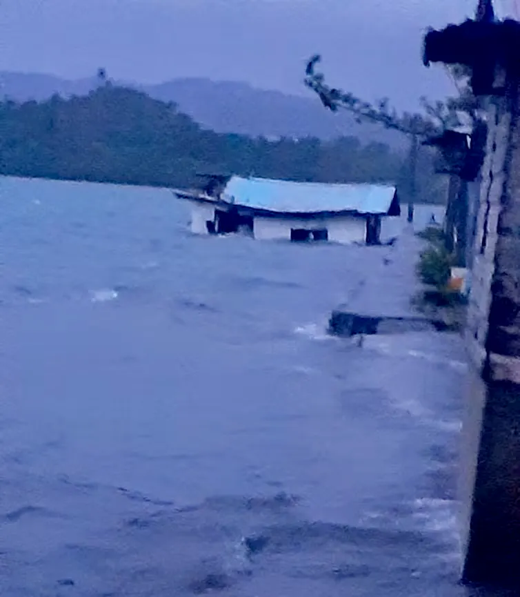 Waves submerge a house