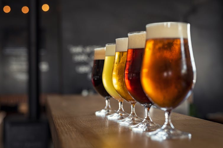 Quatre verres de bière alignés sur une table
