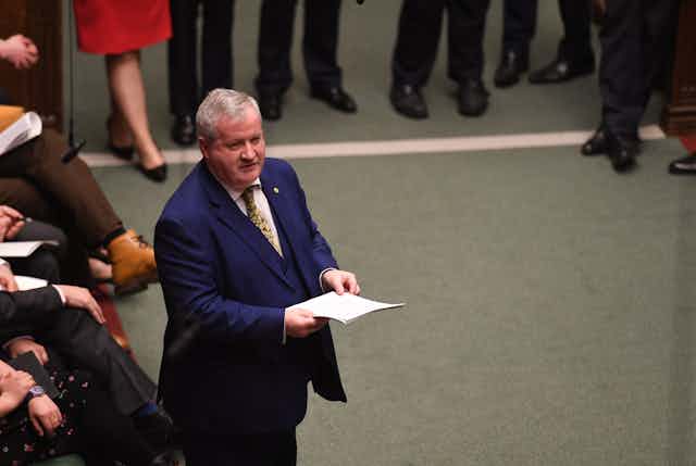 Ian Blackford standing in the House of Commons, delivering a speech from notes.