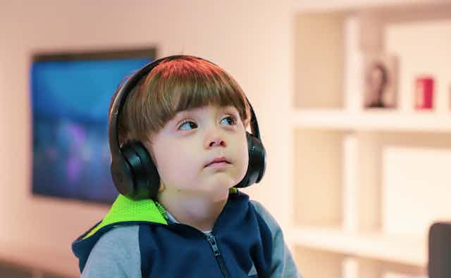 Un niño escucha música con auriculares.