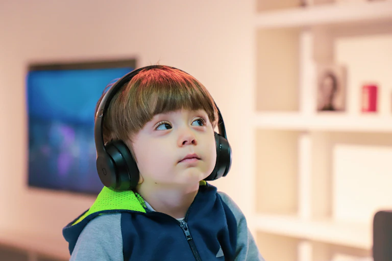 Un niño escucha música con auriculares.