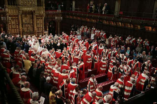 Peers gathering in the House of Lords chamber wearing their ermine robes.
