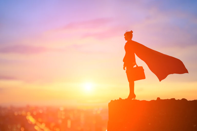 A woman with a cape overlooks a city