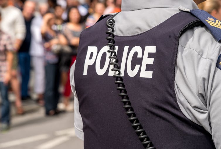 A police officer wearing a protective vest with the word police on it.