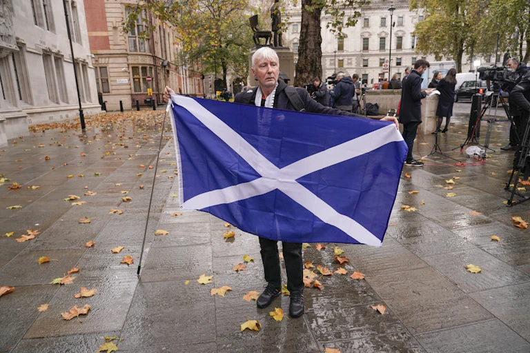 Un homme brandit un drapeau bleu et blanc