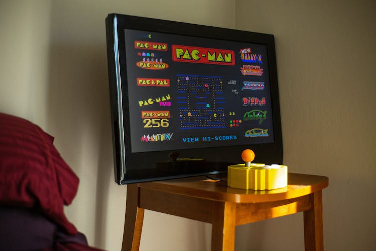 A computer monitor displays the retro Pac-Man video game.