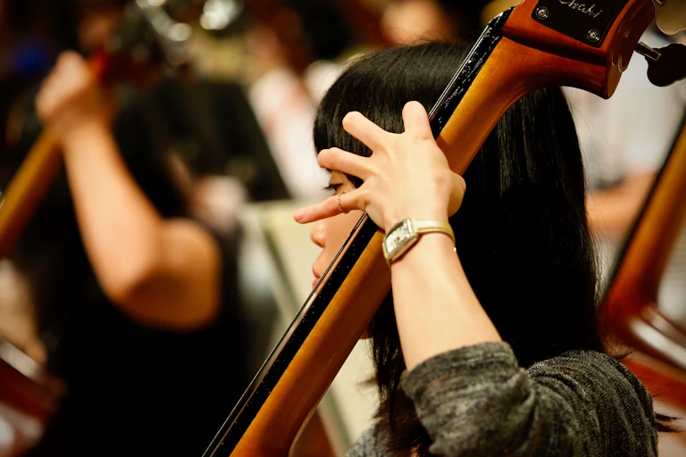 An Asian woman plays a cello