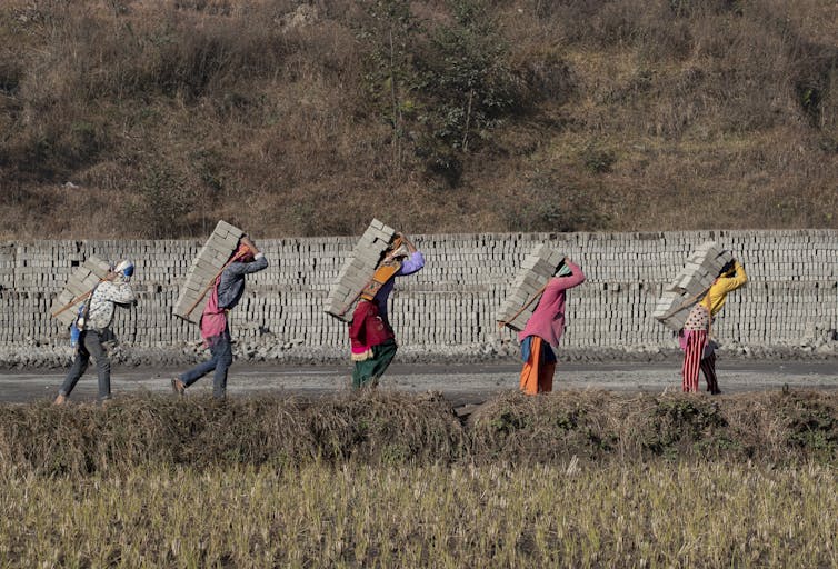 Men carrying bricks.