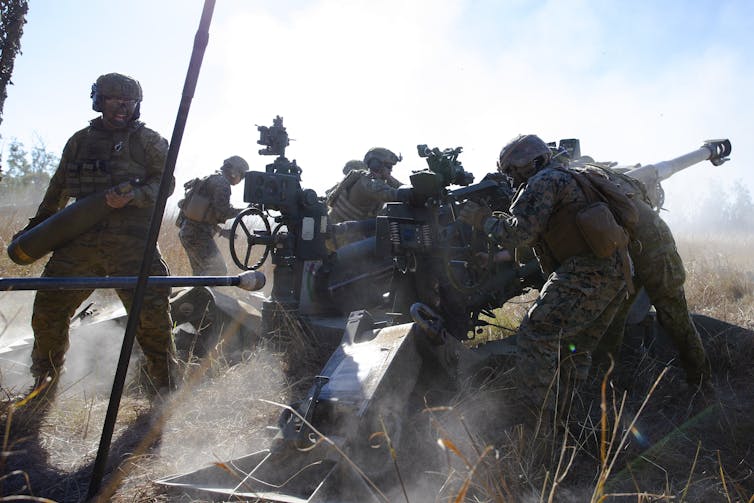 defence personnel fire weapon in training exercise