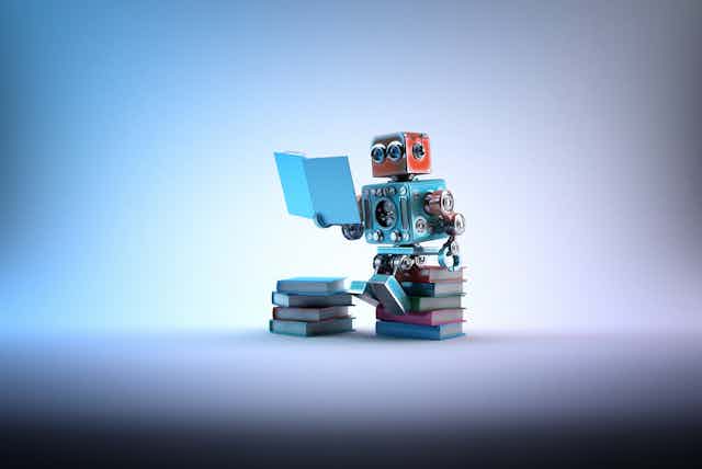 A cartoon robot sits on a pile of books, while reading one 