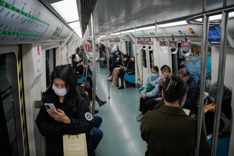 People on a train in Beijing wearing masks.