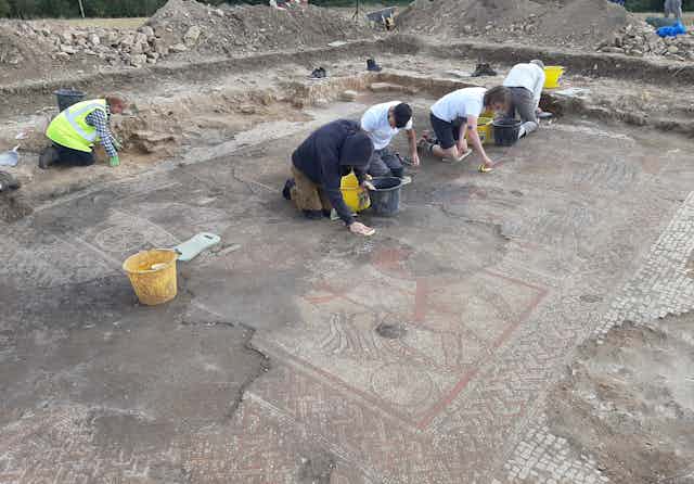 Archaeology students and ULAS staff from University of Leicester carefully clean the fully exposed Trojan War mosaic.  