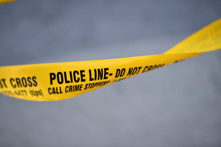 Yellow police tape with the words: Police Line, do not cross, Call crime stoppers.