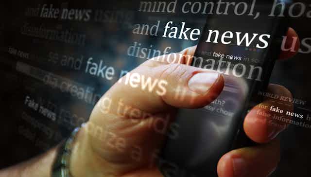 A person's hand is on a mobile phone in an illustration with the words "fake news" and "disinformation" overlayed.