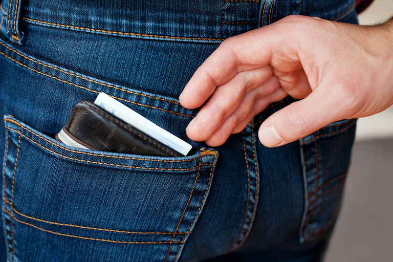 Hand reaching to pickpocket a wallet