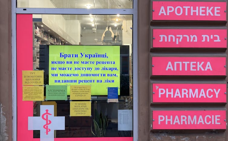 Screen in a window of a pharmacy in Łódź offering help to 'Ukrainian Brothers