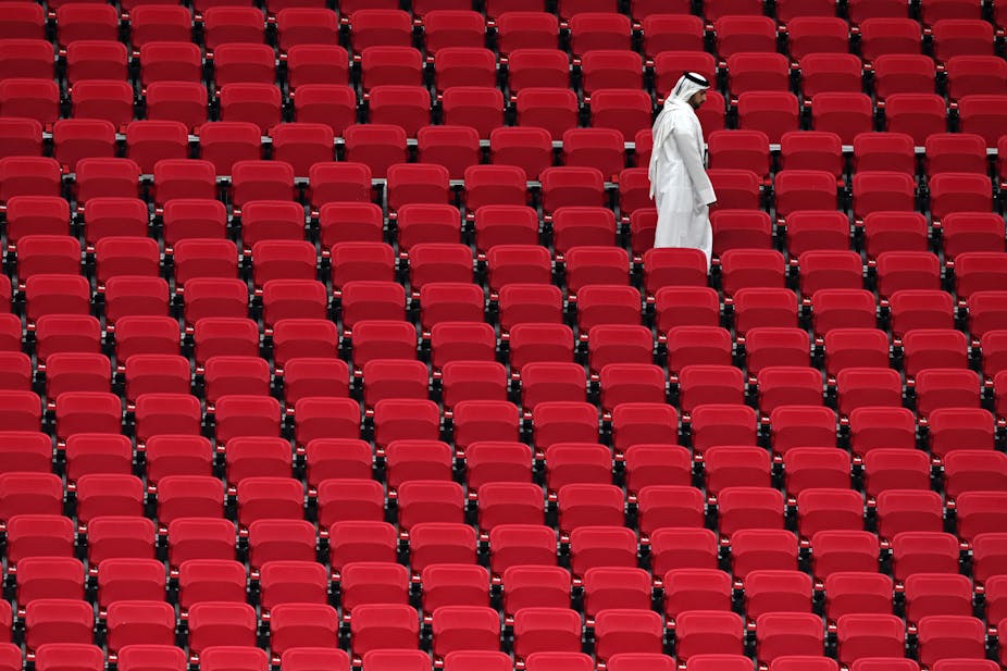 Un homme seul marche dans les gradins d'un stade de Doha au Qatar