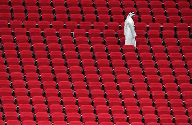 Un homme seul marche dans les gradins d'un stade de Doha au Qatar