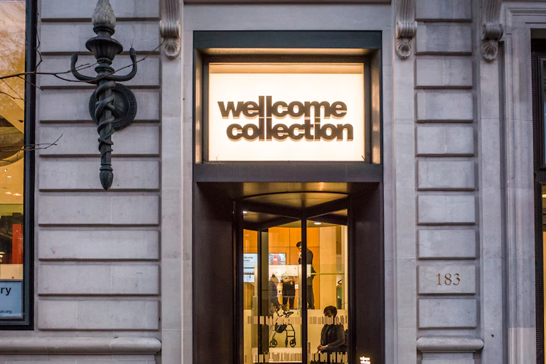 the main doors to the Wellcome Collection lit by a sign emblazoned with the museum's name