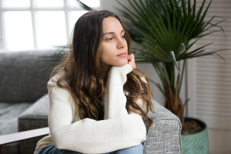 A woman stares out the window pensively.
