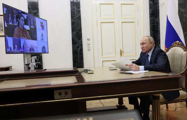 Russian president Vladimir Putin chairs a video meeting from his desk at the Kremlin.