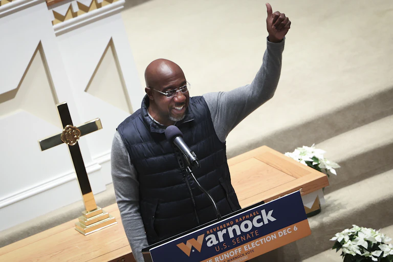 Man gives thumbs up from podium.
