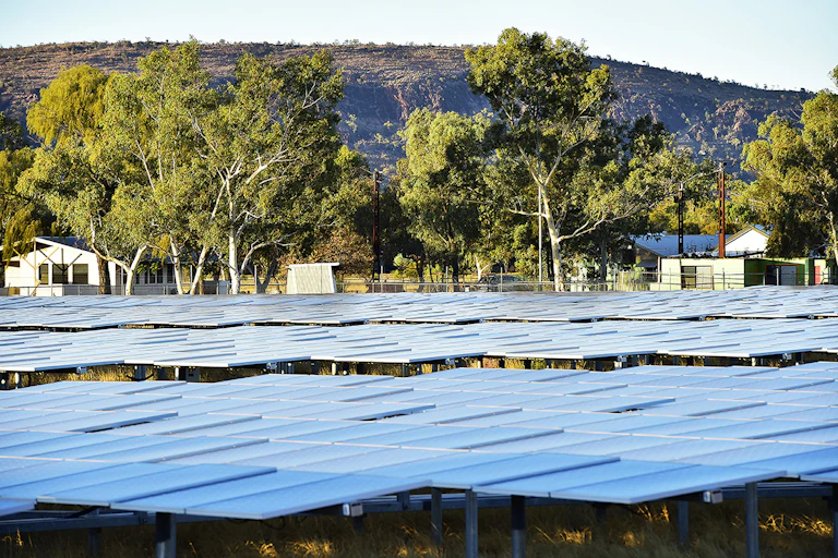 Solar power site in front of rural houses and tree
