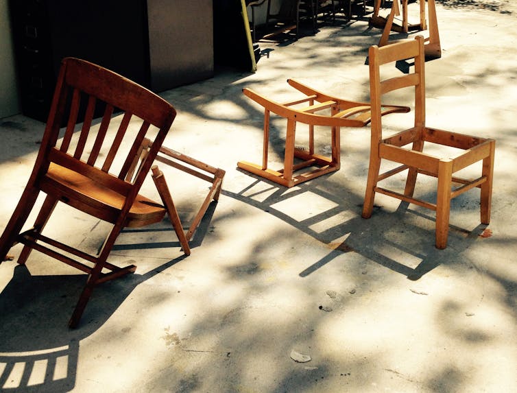 Broken chairs lie on the street.