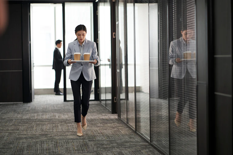 Woman carrying takeaway drinks into office