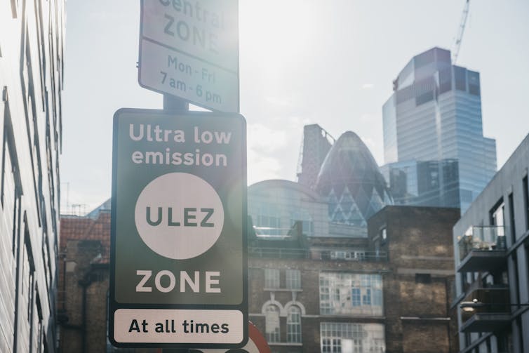 A close-up of a road sign in a city.