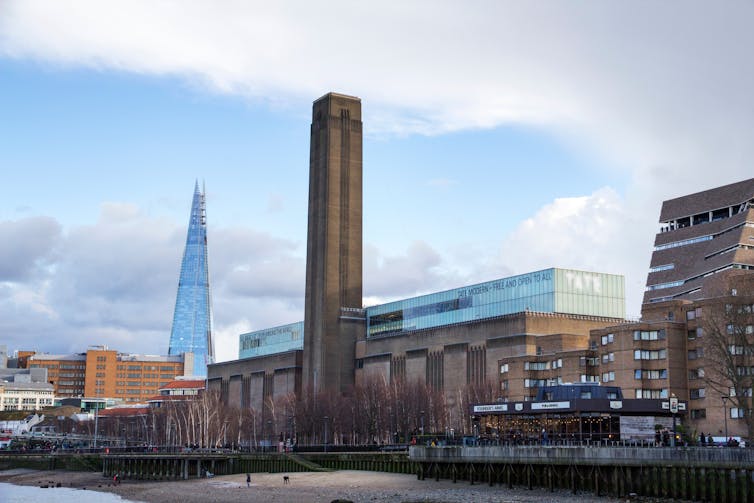 Large building with tall chimney beside a river