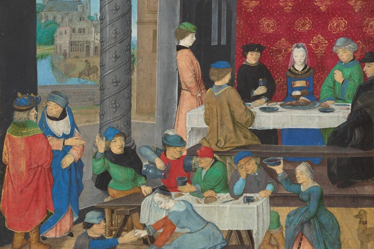 People gathered both standing and sitting in a medieval building.