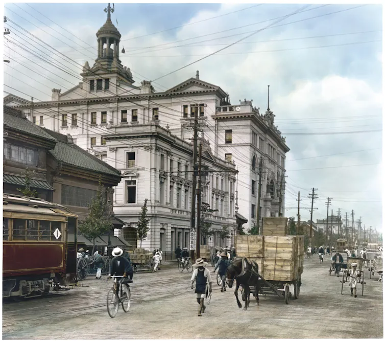 A colourised photograph of a Japanese street showing multiple forms of transportation.