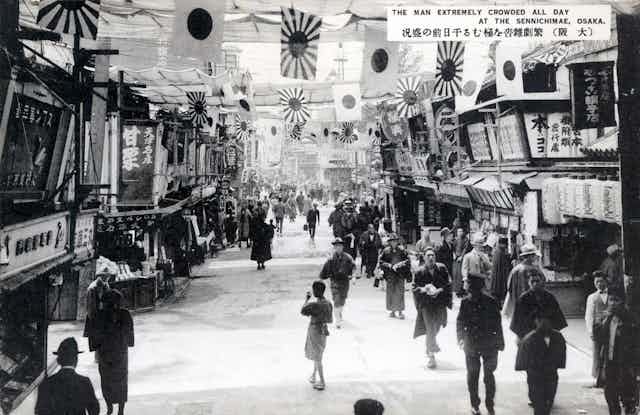 A black and white photograph of a busy street.