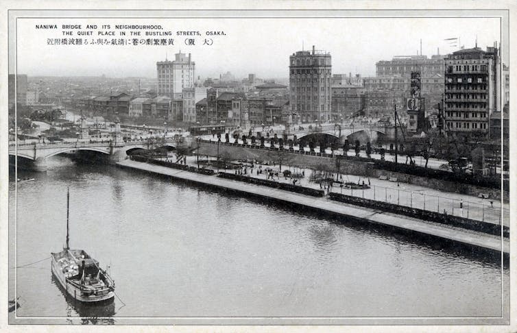 Black and white photo of a river with boats and bridges