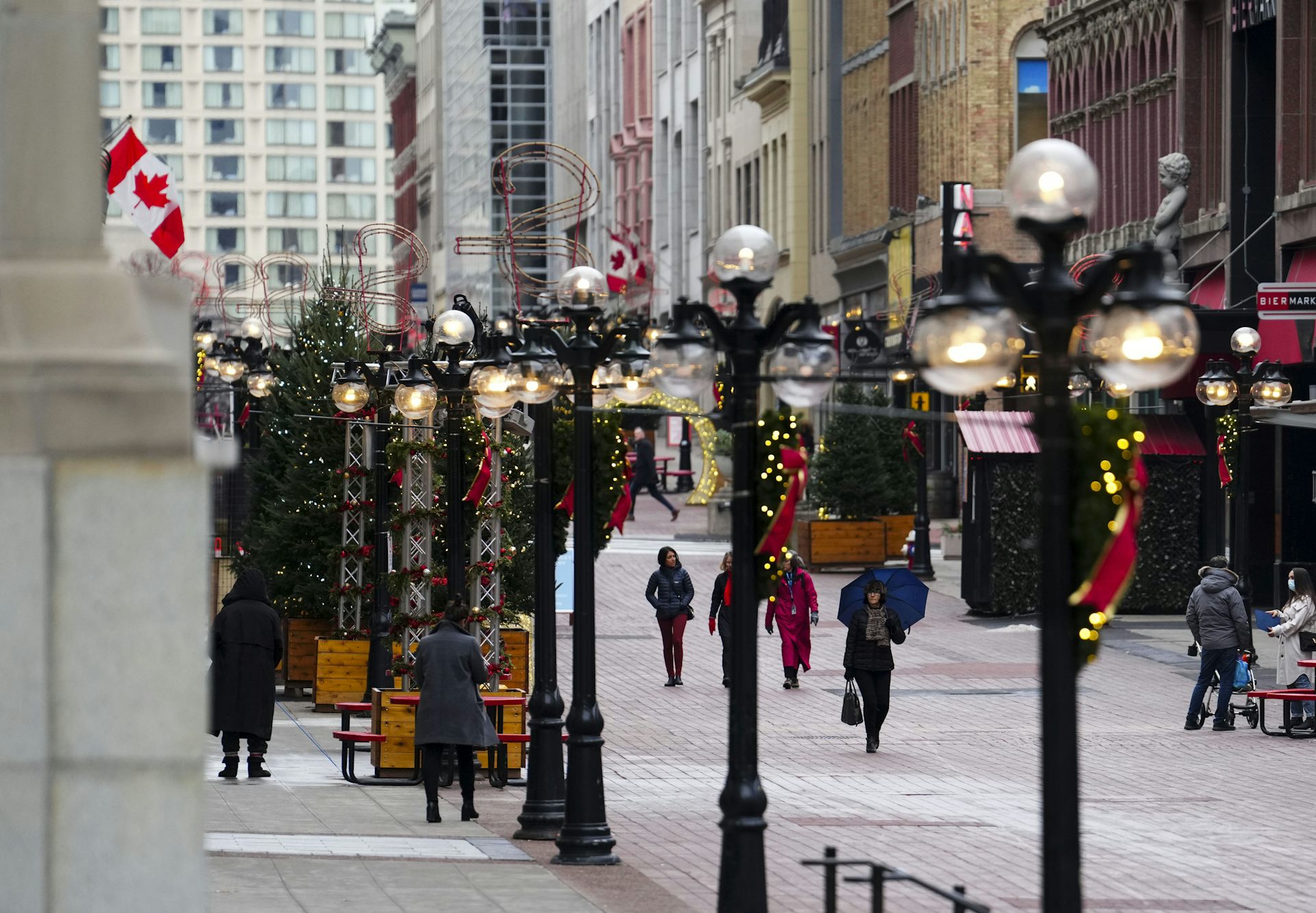Shoppers walk along an outdoor shopping mall.