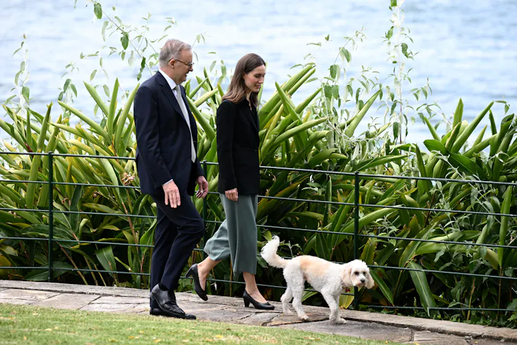 man and woman walk dog