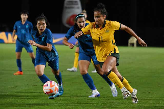 Matildas player Mary Fowler running with the ball against Thai women's football team