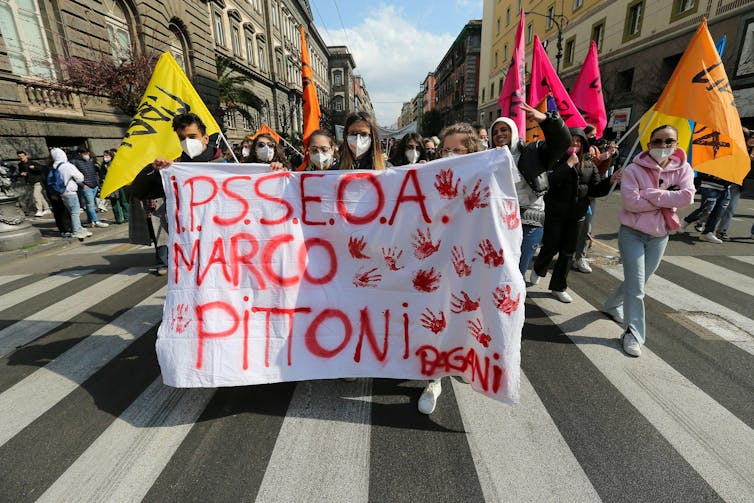 Protesters carrying a banner in city street