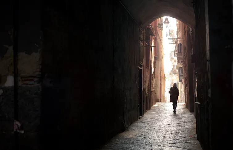 Woman walking away down narrow street