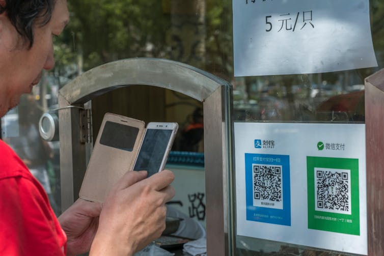 Chinese man using his phone to pay for something