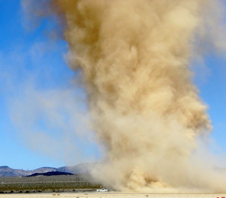 A thick plume of yellow dust rising from the desert.