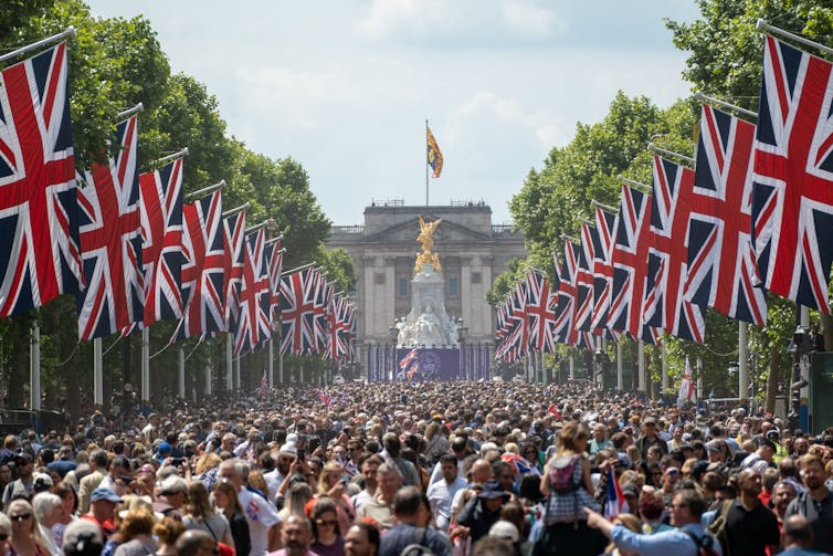 Crowds gather in front of Buckingham Palace.