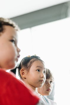 Three young children listening.