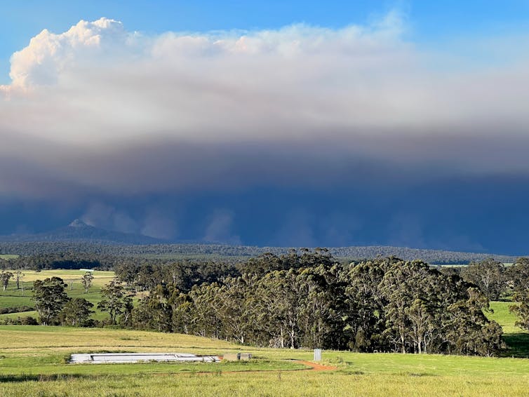 smoke fills the sky above hills