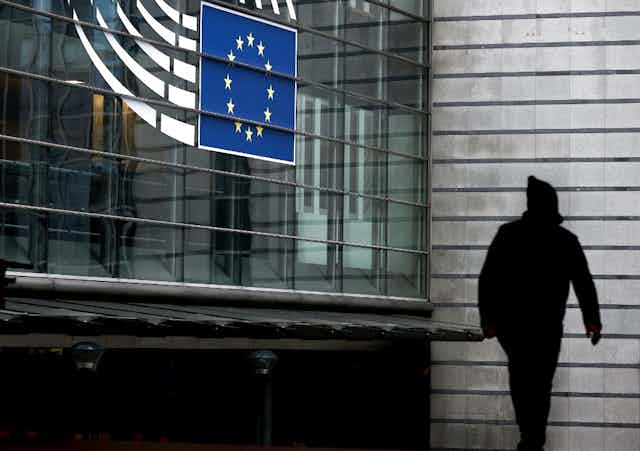 Une personne passe devant l'entrée du Parlement européen à Bruxelles