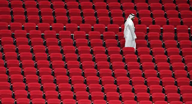 Un hombre solo camina por las gradas de un estadio en Doha, Qatar.