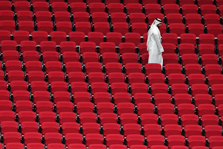Un hombre solo camina por las gradas de un estadio en Doha, Qatar.