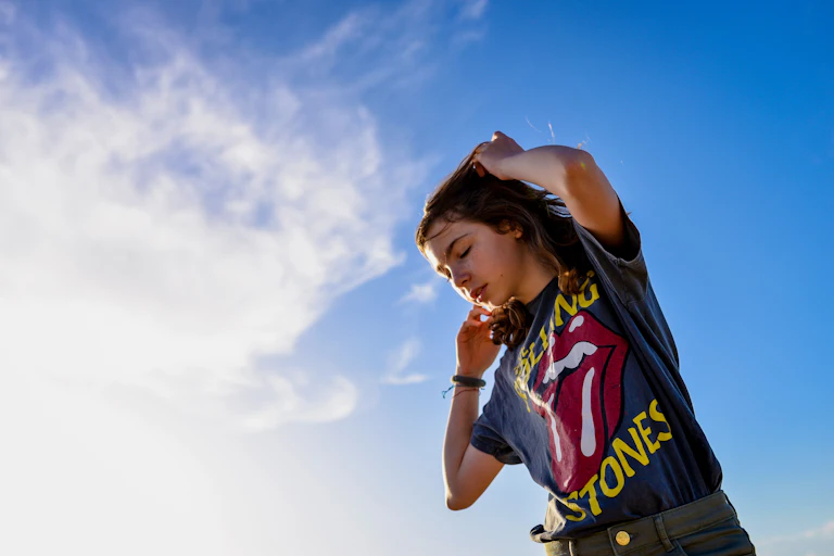 Young woman against blue sky